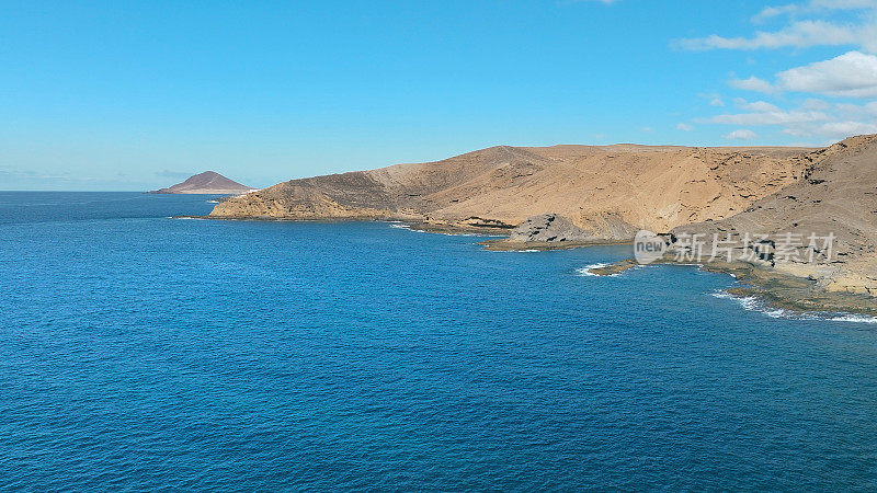 Aerial view of the beach "Playa Escondida" and the natural reserve of "Montaña Pelada" in Tenerife (Canary Islands). Drone shot